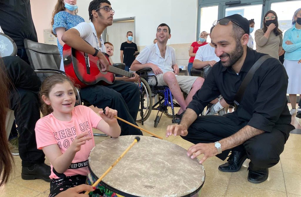 Philharmonic drummer and resident playing drums נגן התזמורת מתופף עם ילדה