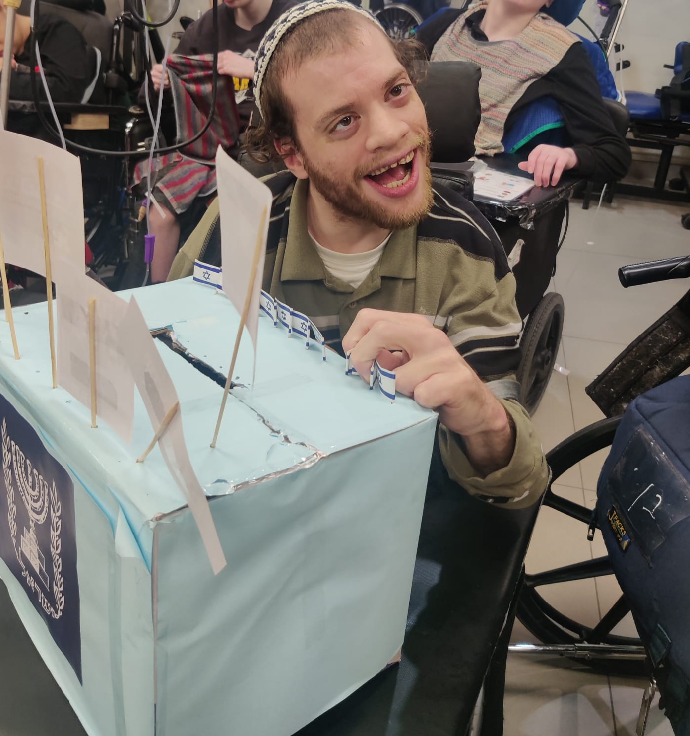 Boy with disabilities holding a voting box בחור עם מגבלויות מחזיק קלפי