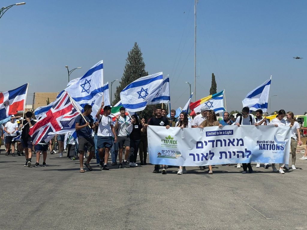 צועדים עם דגלי ישראל ובנאר של מצעד האומותי Marching with Israeli flags and March of Nations banner