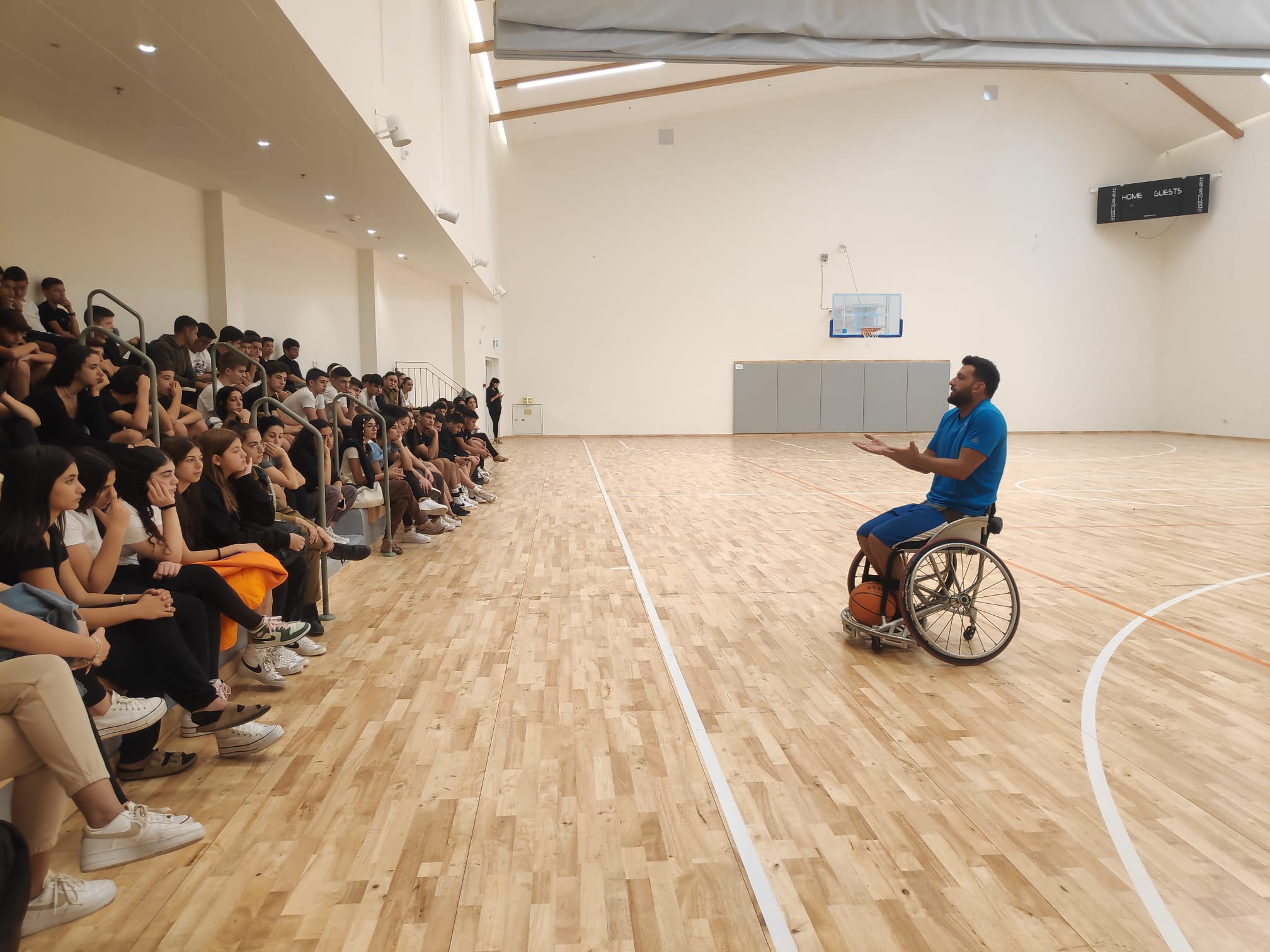 ספוראטי בכסא גלגלים מדבר בפני קהל Athlete in a wheelchair speaking to a crowd