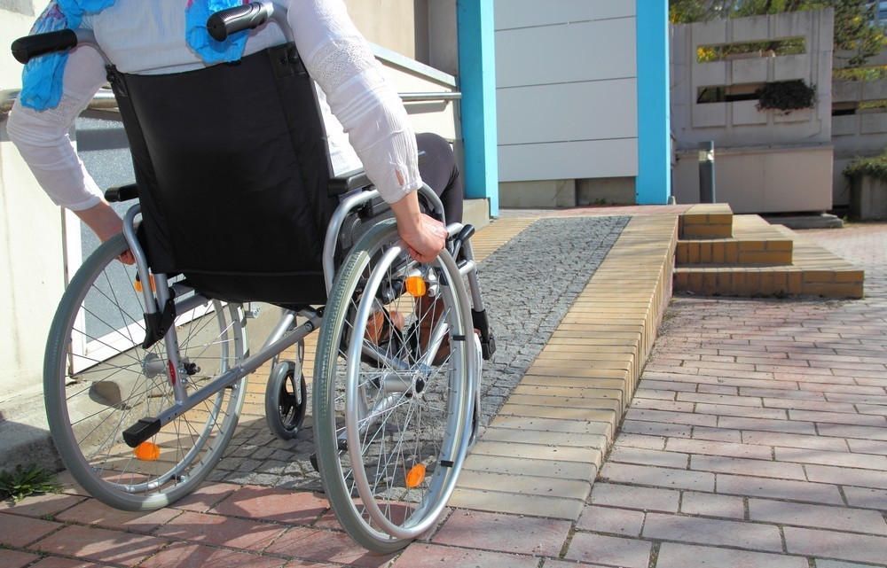 כסא גלגלים עולה בכניסה נגישה Wheelchair going up accessible ramp