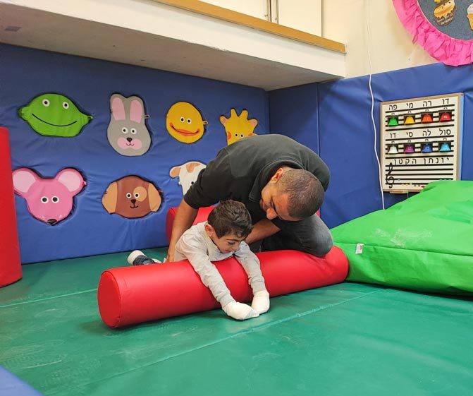 Young boy and therapist doing physiotherapy in the gymboree ילד קטן וטרפיס בתרגול בג'ימבורי