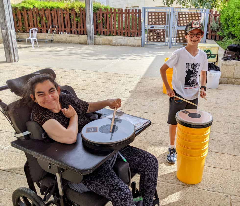 בחורה בכסא גלגלים וילד בתכנית תופים Girl in a wheelchair and boy at drumming activity