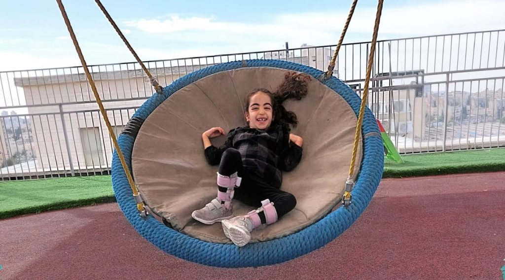 Laughing girl on a spider swing ילדה צוחקת על נדנדת עכביש