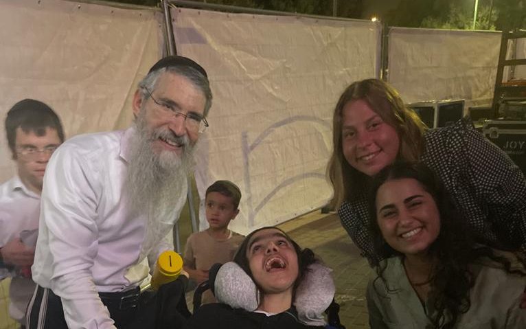 אברהם פריד עם ילד עם מגבלויות בכסא גלגלים Avraham Fried with a boy with disabilities in a wheelchair
